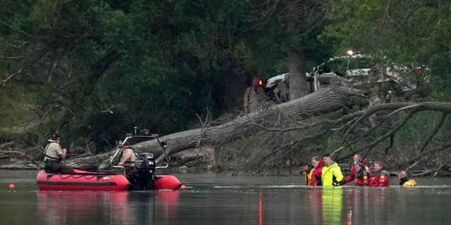 Teams in dry suits and Ramsey County Sheriff's deputies search for the bodies of a mother and her three children at Vadnais Lake, Saturday, July 2, 2022, in Vadnais Heights, Minn.