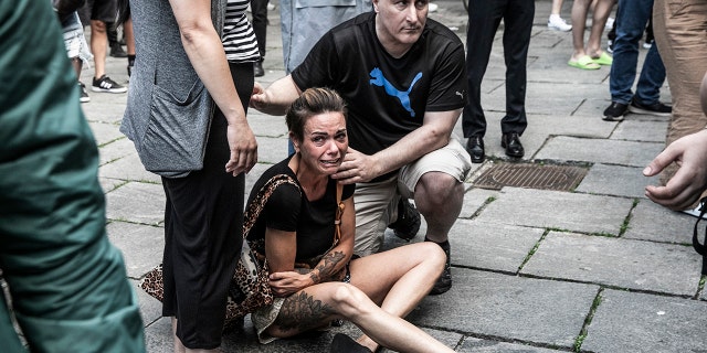 People help a woman in front of the Fields shopping center in Copenhagen, Denmark, Sunday, July 3, 2022.P)