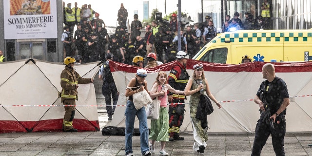 People leave the Field's shopping center in Copenhagen, Denmark Sunday, July 3, 2022, after a gunman opened fire inside, killing three people and critically wounding a few others, police said.