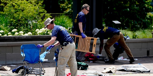 Members of the FBI's evidence response team remove personal belongings a day after a mass shooting in Highland Park, Ill., Tuesday, July 5, 2022.