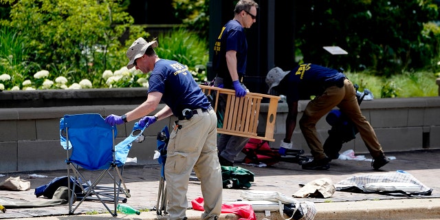 Members of the FBI's evidence response team remove personal belongings one day after a mass shooting in downtown Highland Park, Ill., Tuesday, July 5, 2022.