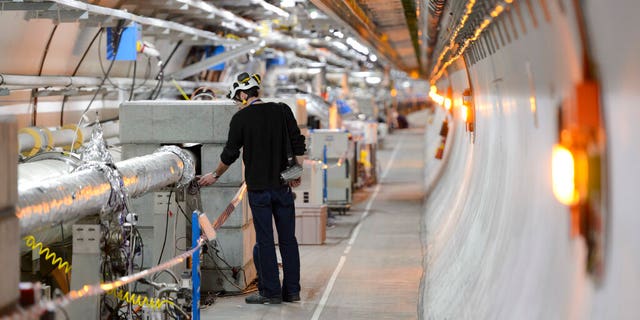 FILE - A technician works in the LHC (Large Hadron Collider) tunnel of the European Organization for Nuclear Research, CERN, during a press visit in Meyrin, near Geneva, Switzerland, Feb. 16, 2016.