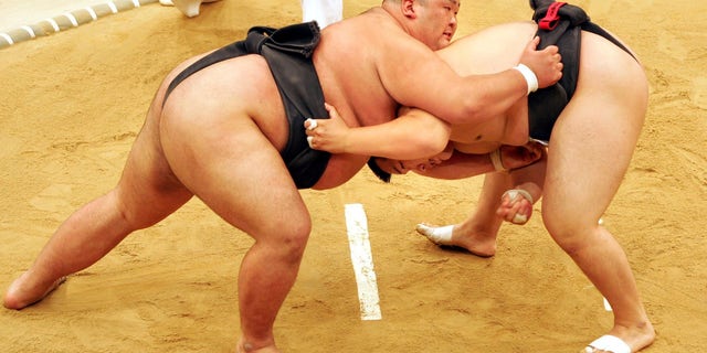 Sumo wrestler Takayuki Ichihara from Japan, left, fights against Keisho Shimoda from Japan, right, at the heavyweight final of the Sumo tournament within the World Games.