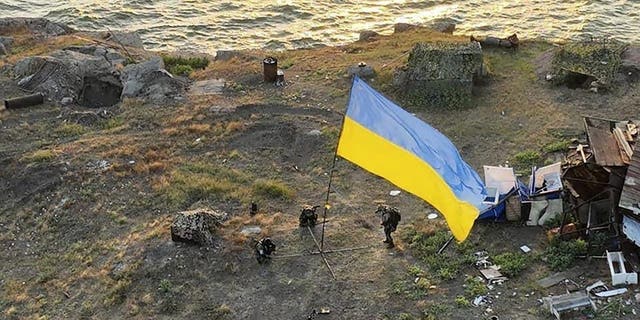 In this photo provided by the press office of the Ukrainian Defense Ministry on July 7, 2022, Ukrainian soldiers install the state flag on the island of snakes in the Black Sea.