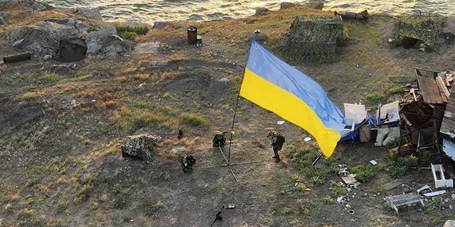 In this photo provided by the Ukrainian Defence Ministry Press Office July 7, 2022, Ukrainian soldiers install the state flag on Snake Island in the Black Sea.