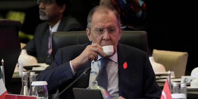 Russian Foreign Minister Sergei Lavrov sips his drink prior to the start of the opening session of the G20 Foreign Ministers' Meeting in Nusa Dua, Bali, Indonesia, Friday, July 8, 2022. 