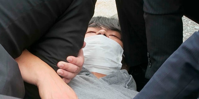 In this image from a video, Tetsuya Yamagami is detained near the site of gunshots in Nara, western Japan Friday, July 8, 2022. Former Japanese Prime Minister Shinzo Abe, an arch-conservative and one of the country's most divisive figures, was shot and critically wounded during a campaign speech Friday in western Japan. He was airlifted to a hospital but officials said he was not breathing and his heart had stopped. Nara prefectural police confirmed the arrest of Yamagami, 41, on suspicion of attempted murder.