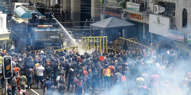 Police use water canon and tear gas to disperse the protesters in Colombo, Sri Lanka, Saturday, July 9, 2022. <a href=