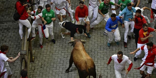 A fighting bull turns to face runners during the running of the bulls event at the Festival of San Fermin in Pamplona, Spain, on Monday, July 11, 2022.