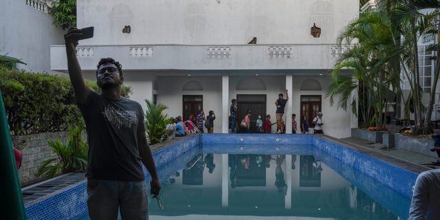 2022년 7월 12일 화요일 스리랑카 콜롬보에서 반정부 시위대의 습격을 받은 고타바야 라자팍사 대통령 관저의 수영장에서 한 남성이 셀카를 찍고 있다. (AP Photo/Rafiq Maqbool)