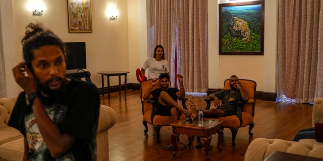 After being attacked by rebel demonstrators in Colombo, Sri Lanka, on Wednesday, July 13, 2022, protesters sit in chairs in President Gotabaya Rajapaksa's official residence.  (AP Photo / Rafiq Maqbool)