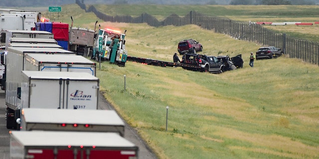 First responders work the scene on Interstate 90 after a fatal pileup where at least 20 vehicles crashed near Hardin, Mont., Friday, July 15, 2022. 
