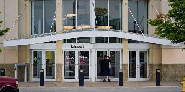 A customer checks a door on the closed Greenwood Park Mall in Greenwood, Indiana, Monday, July 18, 2022.