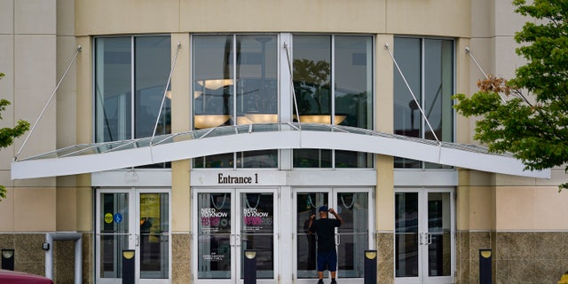 A customer checks a door on the closed Greenwood Park Mall in Greenwood, Indiana, Monday, July 18, 2022.