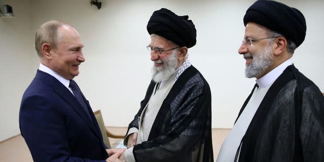Iranian Supreme Leader Ayatollah Ali Khamenei and Russian President Vladimir Putin greet each other as Iranian President Ebrahim Raisi stands at right.
