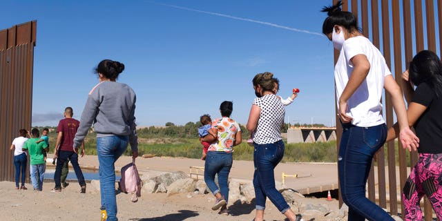 FILE - A group of Brazilian migrants make their way around a gap in the U.S.-Mexico border in Yuma, Ariz., seeking asylum in the U.S. after crossing over from Mexico, June 8, 2021.  (AP Photo/Eugene Garcia, File)