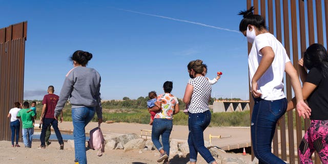 FILE: A group of Brazilian migrants make their way around a gap in the U.S.-Mexico border in Yuma, Ariz., seeking asylum in the U.S. after crossing over from Mexico, June 8, 2021.