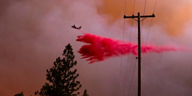 A plane drops retardant while battling the Oak Fire in Mariposa County, Calif., on Friday, July 22, 2022.