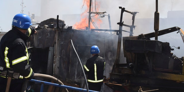 firefighters put out a fire in a port after a Russian missiles attack in Odesa, Ukraine