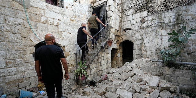 Los palestinos inspeccionan los daños a una casa después de que palestinos armados fueran asesinados en una redada militar israelí a primera hora de la mañana en la Ciudad Vieja de Naplusa, en Cisjordania, el domingo 24 de julio de 2022. 