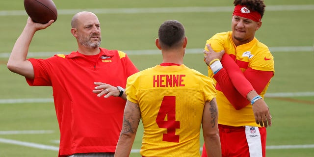 Kansas City Chiefs quarterback Patrick Mahomes, right, stretches as he stands next to quarterbacks coach Matt Nagy, left, and backup quarterback Chad Henne (4) before a morning at training camp at Missouri Western State University in St. Joseph, Mo., July 24, 2022.