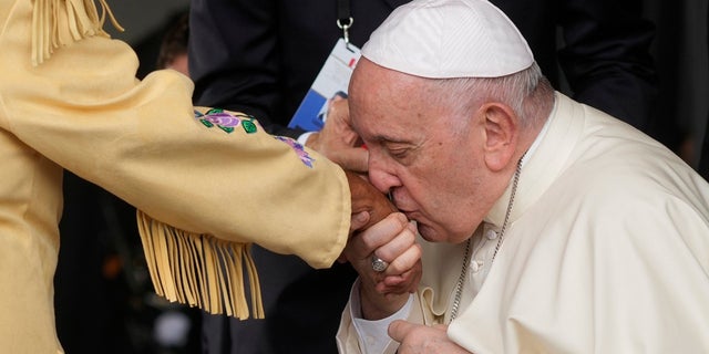 Pope Francis kisses hand of Canadian Indigenous woman as he arrives at Edmonton's International airport, Canada, Sunday, July 24, 2022. Pope Francis begins a weeklong trip to Canada on Sunday to apologize to Indigenous peoples for the abuses committed by Catholic missionaries in the country's notorious residential schools. (G3 Box News Photo/Gregorio Borgia)