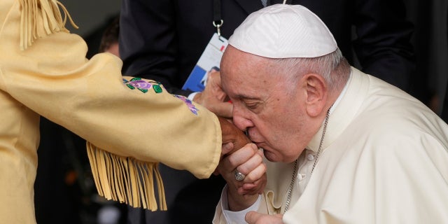 Pope Francis kisses hand of Canadian Indigenous woman as he arrives at Edmonton's International airport, Canada, Sunday, July 24, 2022. The pope apologize to Indigenous peoples for the abuses committed by Catholic missionaries in the country's notorious residential schools.