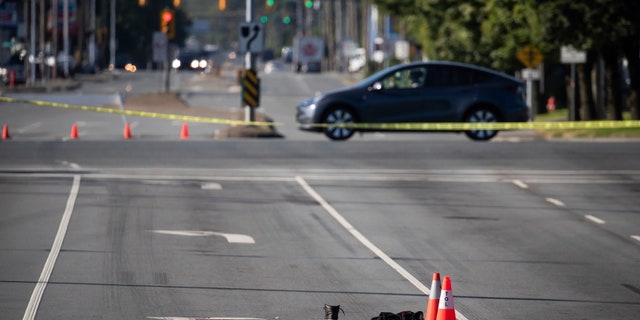 A shoe with blood on it and other belongings are seen on the road behind police tape at the scene of a shooting in Langley, British Columbia. Canadian police reported multiple shootings of homeless people Monday in a Vancouver suburb.