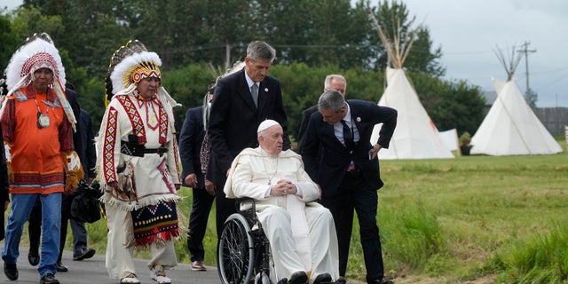 Pope Francis leaves with the indigenous people on Monday, July 25, 2022, after praying at the former residential school graveyard in Maskwacis, near Edmonton, Canada.