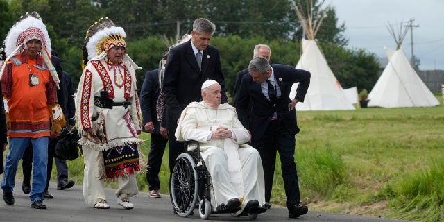 Pope Francis leaves with Indigenous peoples after praying in a cemetery at the former residential school, in Maskwacis, near Edmonton, Canada, Monday, July 25, 2022. Pope Francis begins a "penitential" visit to Canada to beg forgiveness from survivors of the country's residential schools, where Catholic missionaries contributed to the "cultural genocide" of generations of Indigenous children by trying to stamp out their languages, cultures and traditions. Francis set to visit the cemetery at the former residential school in Maskwacis. (AP Photo/Gregorio Borgia)