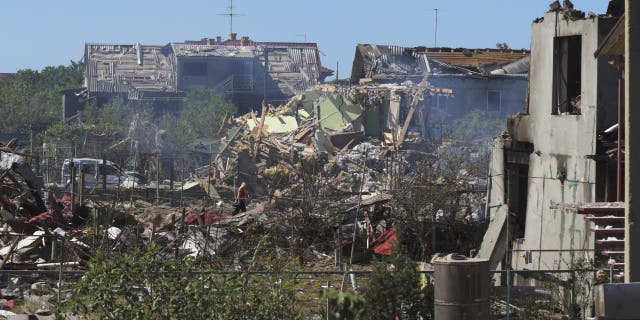 A woman walks among apartment buildings destroyed by Russian shelling on the outskirts of Odesa, Ukraine, Tuesday, July 26, 2022.