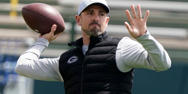 FILE - Green Bay Packers' head coach Matt LaFleur throws a pass at the NFL football team's practice field training camp Tuesday, May 24, 2022, in Green Bay, Wis.