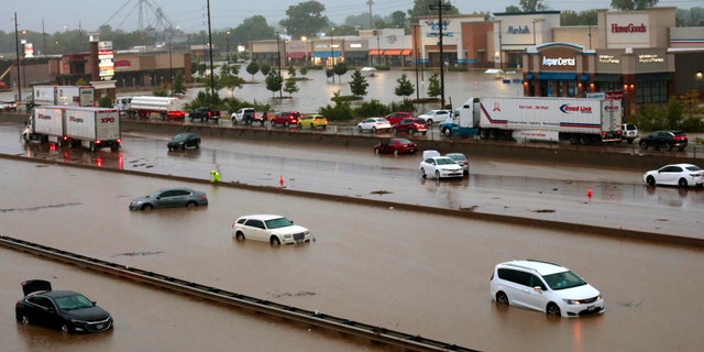 Abandoned cars are scattered by flooding across a shuttered Interstate 70 at Mid Rivers Mall Drive in St. Peters after heavy rain fell through the night and into the morning.