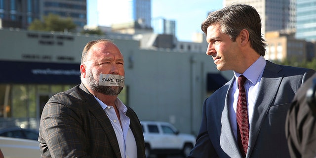 Alex Jones arrives at the Travis County Courthouse in Austin, Texas, Tuesday, July 26, 2022, with a piece of tape over his mouth that reads "save the 1st." 