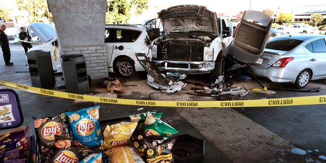 Police investigate a car accident at a gas station in the Panorama City section of Los Angeles on Tuesday, July 26, 2022. 