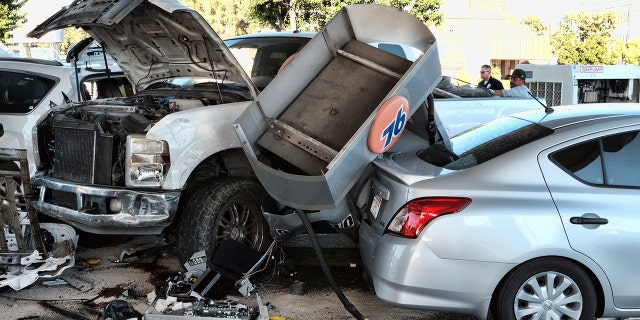 Police investigate a car accident at a gas station in the Panorama City section of Los Angeles on Tuesday, July 26, 2022.