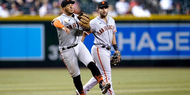 San Francisco Giants shortstop Thairo Estrada throws to first base as Giants third baseman David Villar, right, backs up the play during the seventh inning against the Arizona Diamondbacks, July 26, 2022, in Phoenix, Arizona.