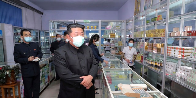 En esta foto proporcionada por el gobierno de Corea del Norte, el líder norcoreano Kim Jong Un, centro, visita una farmacia en Pyongyang, Corea del Norte, el 15 de mayo de 2022. 