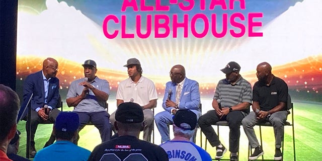 From left, Seattle Mariners announcer Dave Sims, retired All-Stars Andre Dawson and Tim Raines, Negro Leagues Museum president Bob Kendrick, former All-Stars Edwin Jackson and Jimmy Rollins pose for fans after a panel, Monday, July 18, 2022, on the life and legacy of Jackie Robinson in Los Angeles.