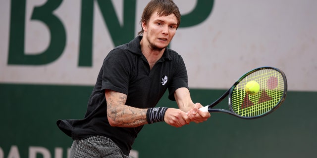 Alexander Bublik of Kazakhstan plays a backhand against Arthur Rinderknech of France during the Men's Singles First Round match on Day 3 of the French Open at Roland Garros on May 24, 2022 in Paris, France.