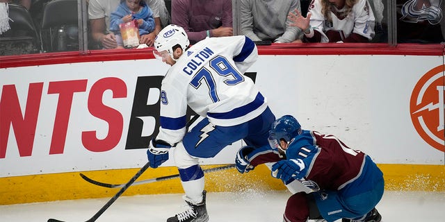 Tampa Bay Lightning center Ross Colton, left, collects the puck as Colorado Avalanche center Andrew Cogliano defends during the first period of Game 5 of the NHL hockey Stanley Cup Final on Friday, June 24, 2022, in Denver. 