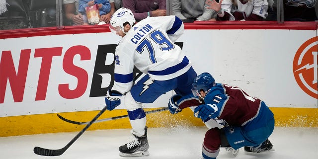 Tampa Bay Lightning center Ross Colton, left, collects the puck as Colorado Avalanche center Andrew Cogliano defends during the first period of Game 5 of the NHL hockey Stanley Cup Final on Friday, June 24, 2022, in Denver. 