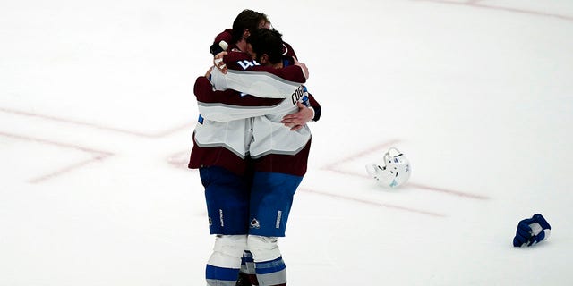 Colorado Avalanche defenseman Josh Manson (42), left, hugs center Andrew Cogliano (11) after the Avalanche defeated the Tampa Bay Lightning, 2-1 to win the NHL hockey Stanley Cup Finals on Sunday, June 26, 2022, in Tampa, Fla. 