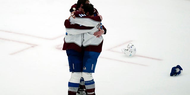 Colorado Avalanche defenseman Josh Manson (42), left, hugs center Andrew Cogliano (11) after the Avalanche defeated the Tampa Bay Lightning, 2-1 to win the NHL hockey Stanley Cup Finals on Sunday, June 26, 2022, in Tampa, Fla. 