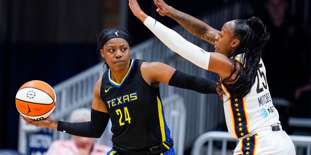 Dallas Wings guard Arike Ogunbowale (24) holds off Indiana Fever guard Tiffany Mitchell (25) in the first half of a WNBA basketball game in Indianapolis, Sunday, July 24, 2022.
