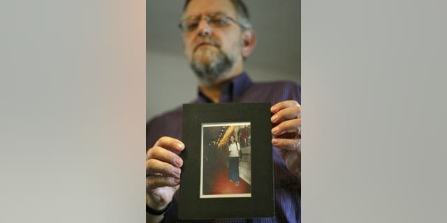 FILE - Arnold Roth holds a photo of his 15-year-old daughter Malki, who was killed in an August 2001 Palestinian suicide bombing at a Jerusalem pizzeria, at his house in Jerusalem, on Sept. 28, 2004. (AP Photo/Oded Balilty)