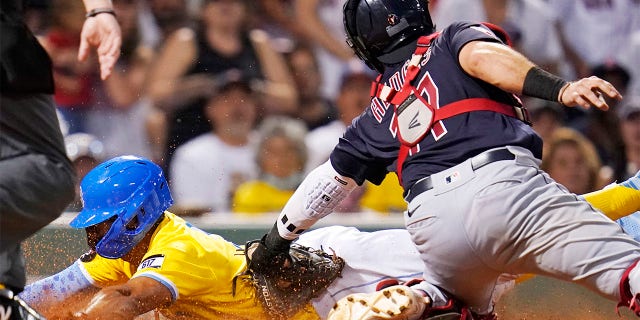 Cleveland Guardians catcher Austin Hedges, right, tags out Boston Red Sox's Xander Bogaerts, who was while trying to score on a fly out by Kevin Plawecki during the third inning during a baseball game at Fenway Park, Tuesday, July 26, 2022, in Boston.