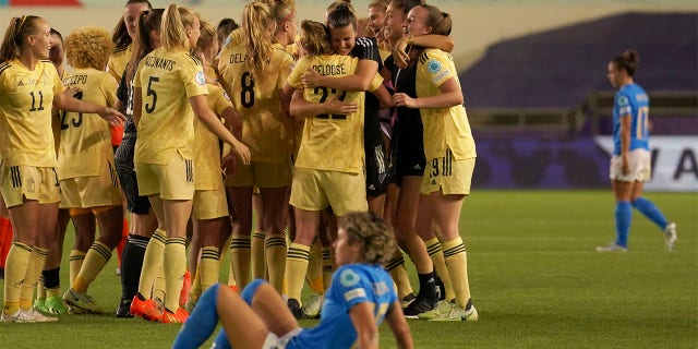 Italy's Valentina Giacinti sits on the ground while Belgium players celebrate in the background at the end of the Women Euro 2022 group D soccer match between Italy and Belgium at the Manchester City Academy Stadium, in Manchester, England, Monday, July 18, 2022. Belgium won 1-0 to advance to the quarterfinals.
