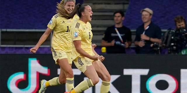 Belgium's Tine De Caigny, right, celebrates after scoring the opening goal during the Women Euro 2022 group D soccer match between Italy and Belgium at the Manchester City Academy Stadium, in Manchester, England, Monday, July 18, 2022.