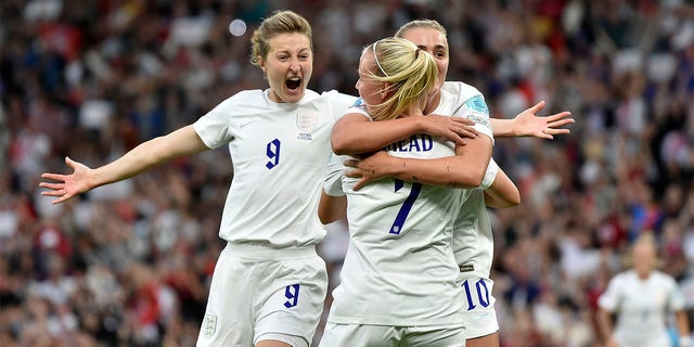 Beth Mead, center, of England celebrates with Ellen White, left and Georgia Stanaway after scoring the opening goal during the Women's Euro 2022 football match between England and Austria at Old Trafford in Manchester, England, Wednesday, July 6, 2022 . 